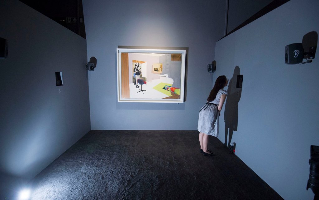 A woman in a dimly lit room starting at a wall