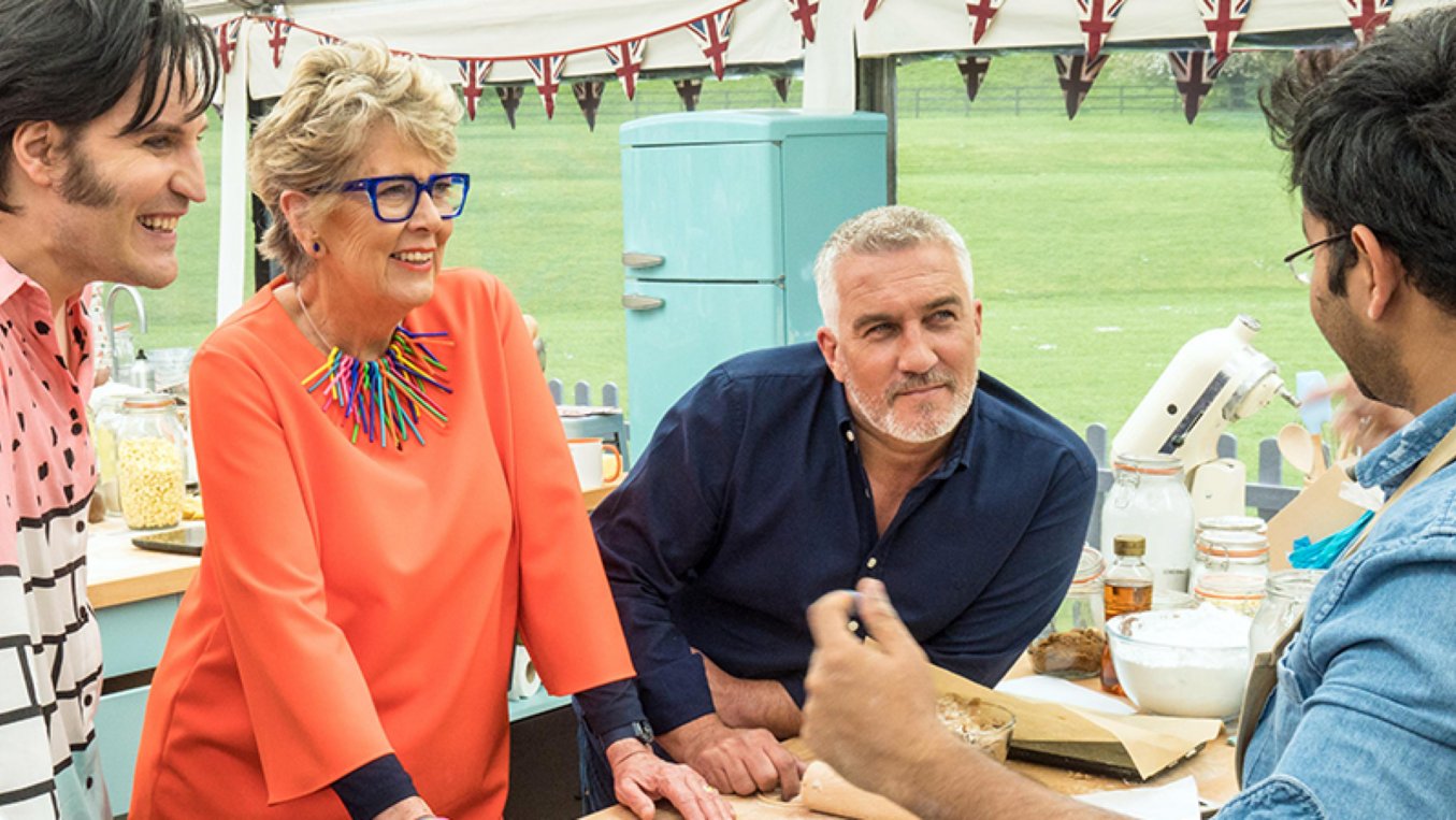 The Great British Bakeoff judges talking to a contestant 